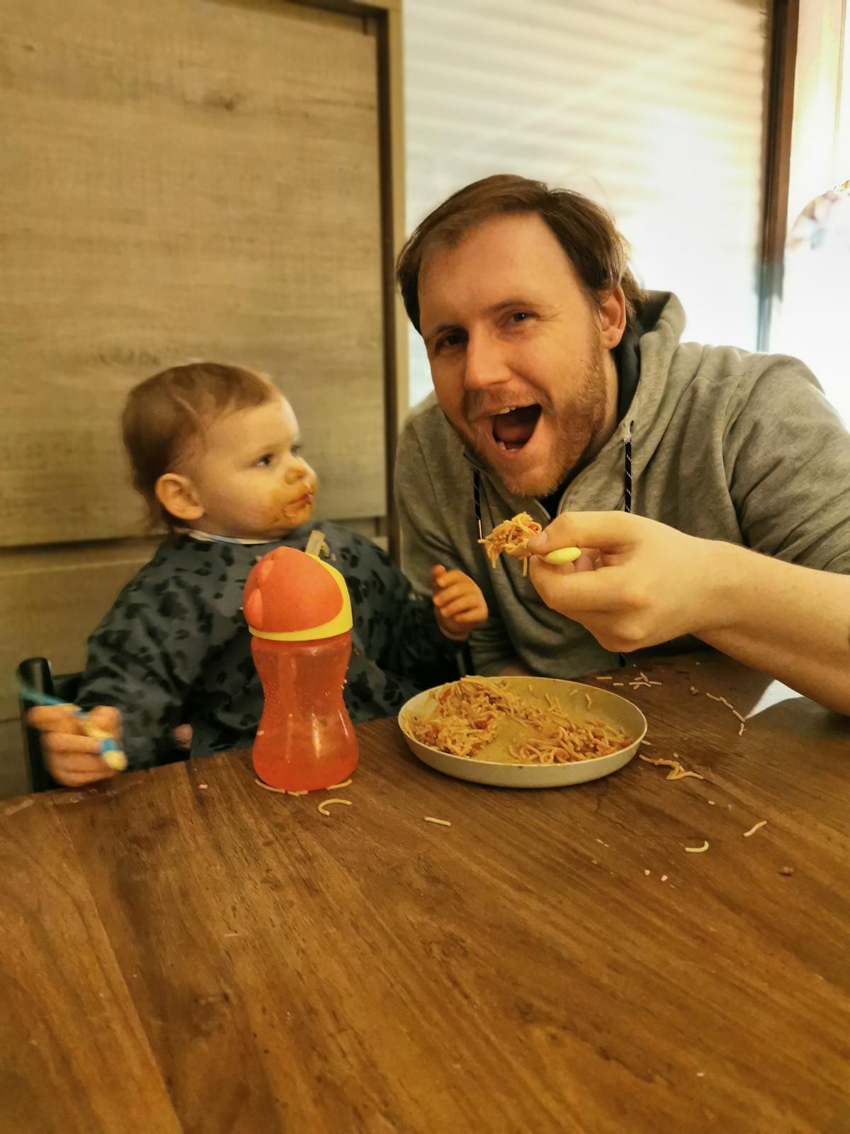 Papa Yannick helpt peuter Seth met spaghetti eten