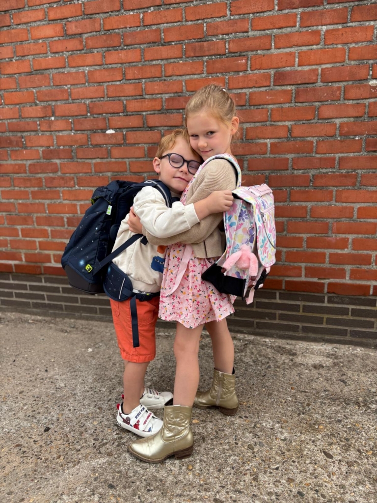 Skyler-Lily omhelst haar broer Seth, allebei met hun boekentas op de rug
